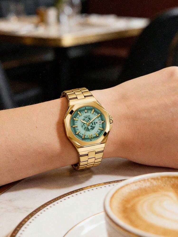 Gold-tone Super Nova watch with turquoise dial on wrist, lifestyle wear shot
