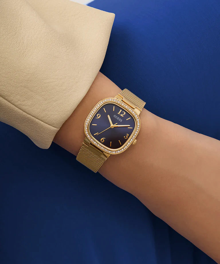 Guess Tapestry watch worn on wrist with gold mesh strap and blue dial