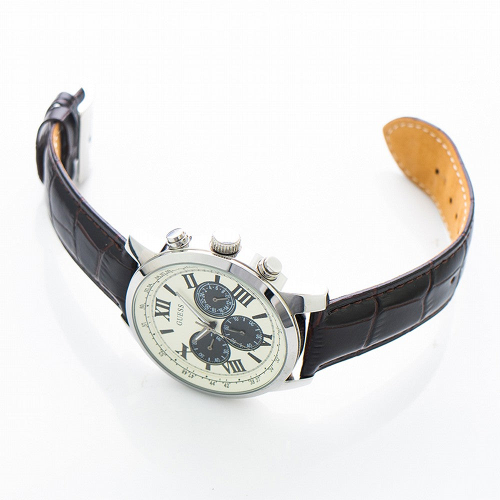 Guess men's chronograph watch at angle showing white dial with black subdials and leather band