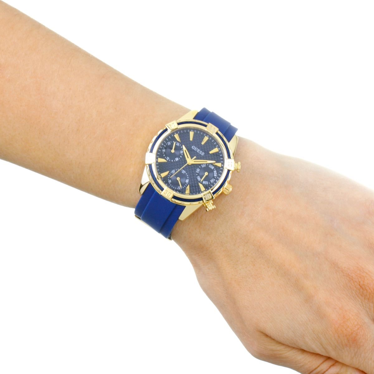 Guess W0562L2 women's watch worn on wrist with blue strap and gold-tone case