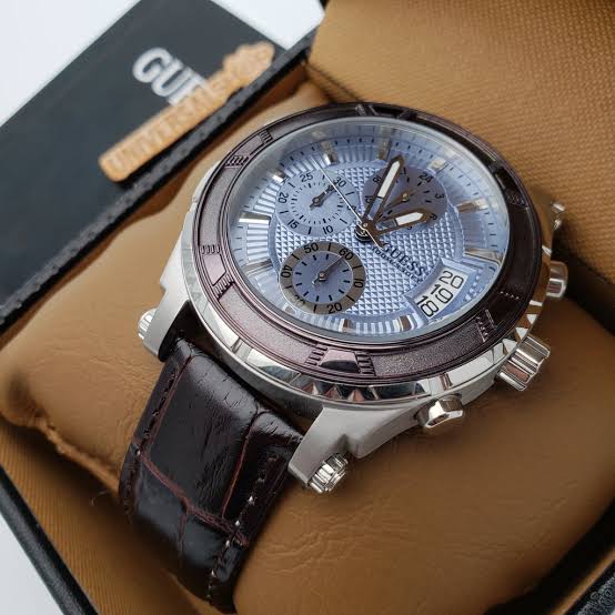 Guess chronograph watch on wrist with blue dial and dark crocodile-textured leather strap
