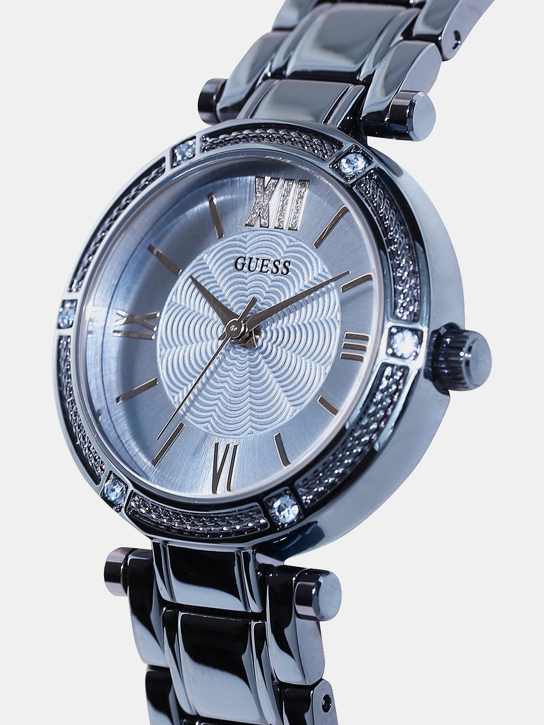 Angled view of Guess blue dial watch with crystal-accented bezel and Roman numeral markers