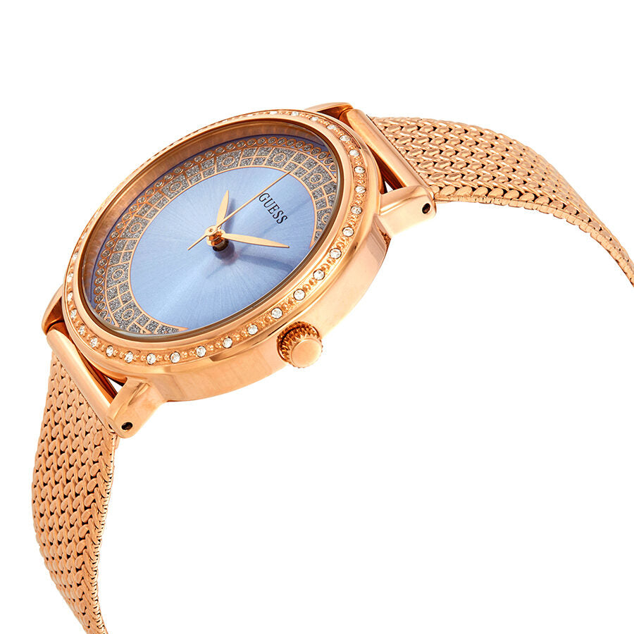 Guess Willow watch angled view showing rose gold case, mesh strap, and blue sunburst dial