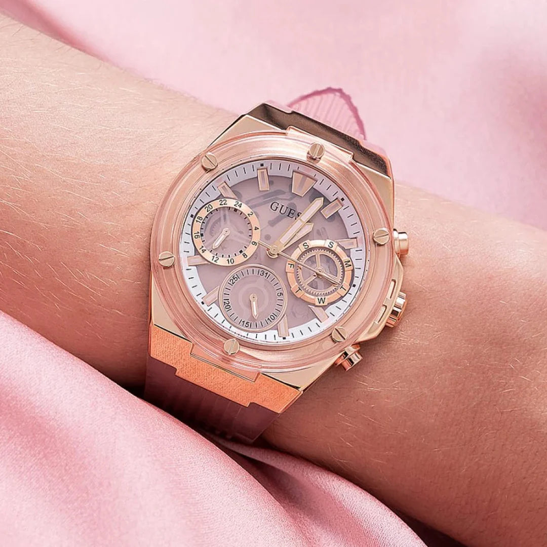 Guess Athena rose gold chronograph watch displayed on wrist against pink background