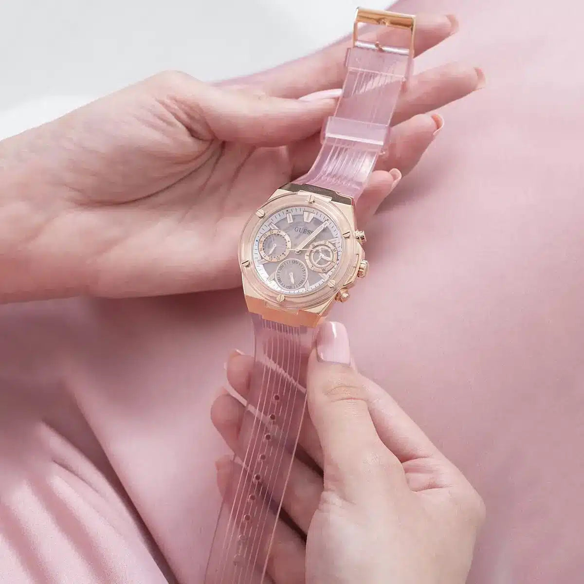 Guess Athena rose gold chronograph watch worn on wrist with rose gold rubber strap
