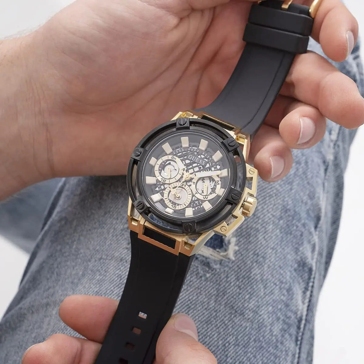 Guess Matrix watch on wrist with black rubber strap and gold case visible