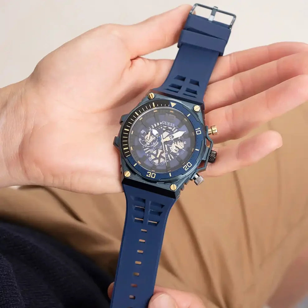 GUESS GW0443G1 blue multifunction watch held in hand showing dial and rubber strap