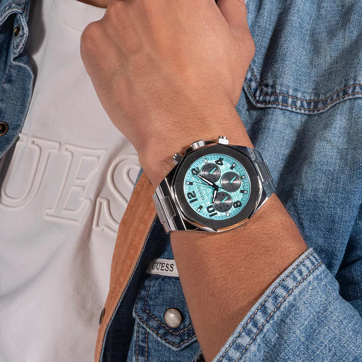 Guess GW0489G3 silver chronograph watch worn on wrist showing turquoise dial