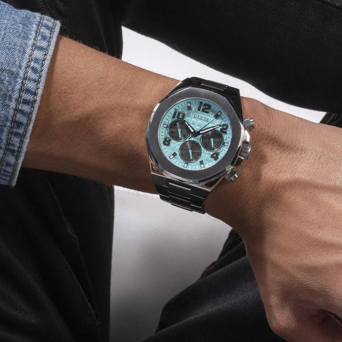 Guess GW0489G3 men's watch on wrist with turquoise dial and chronograph subdials