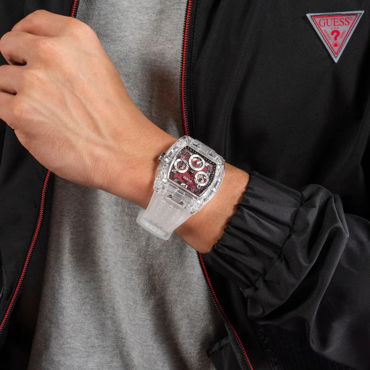 Guess Phoenix watch worn on wrist showing burgundy dial and transparent strap