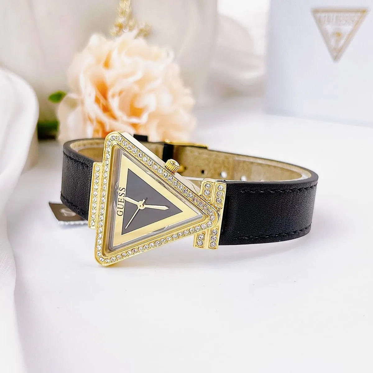GUESS GW0504L5 watch displayed with decorative elements showing triangular case design and black leather strap