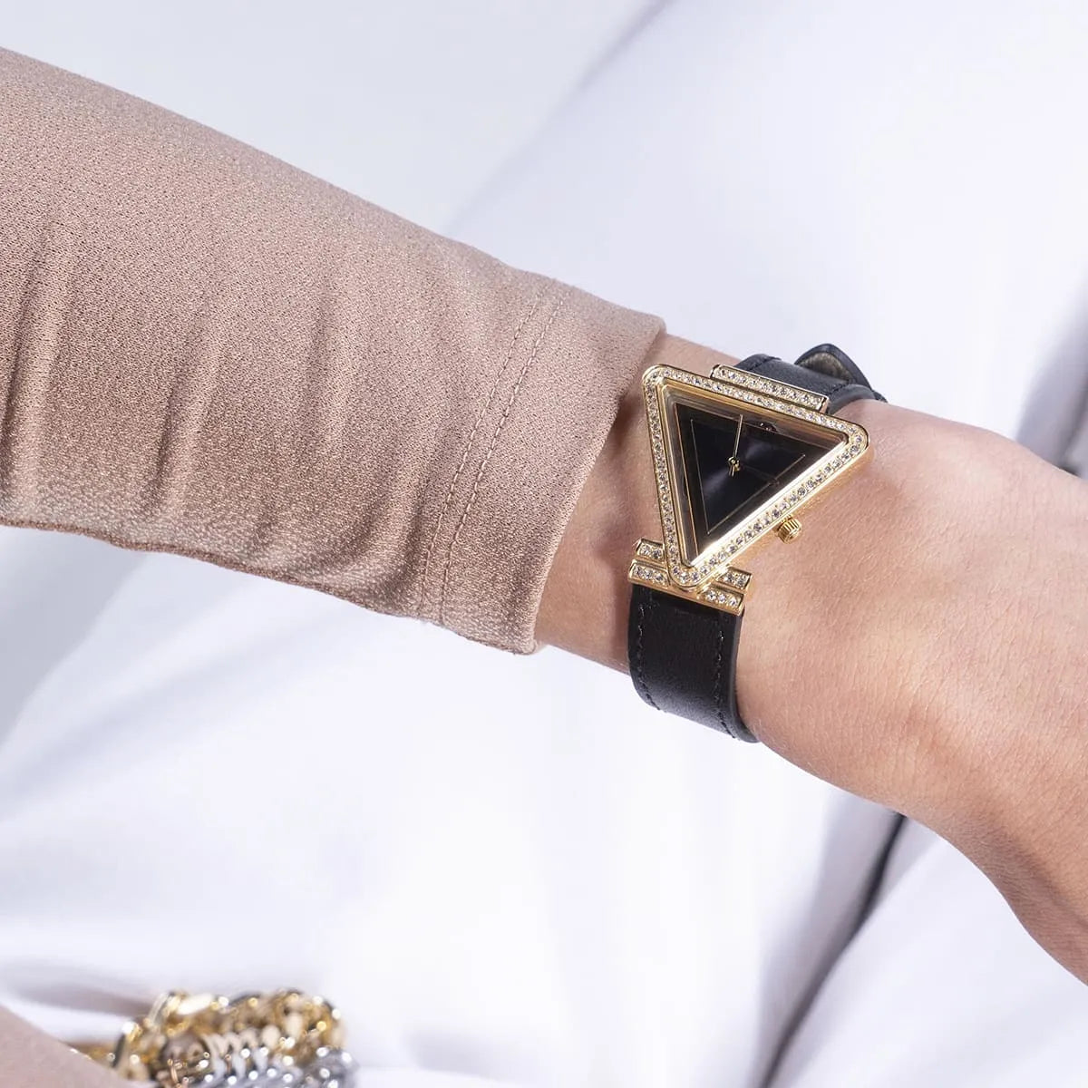 GUESS GW0504L5 ladies watch worn on wrist showing gold-tone triangle case with crystal bezel and black dial