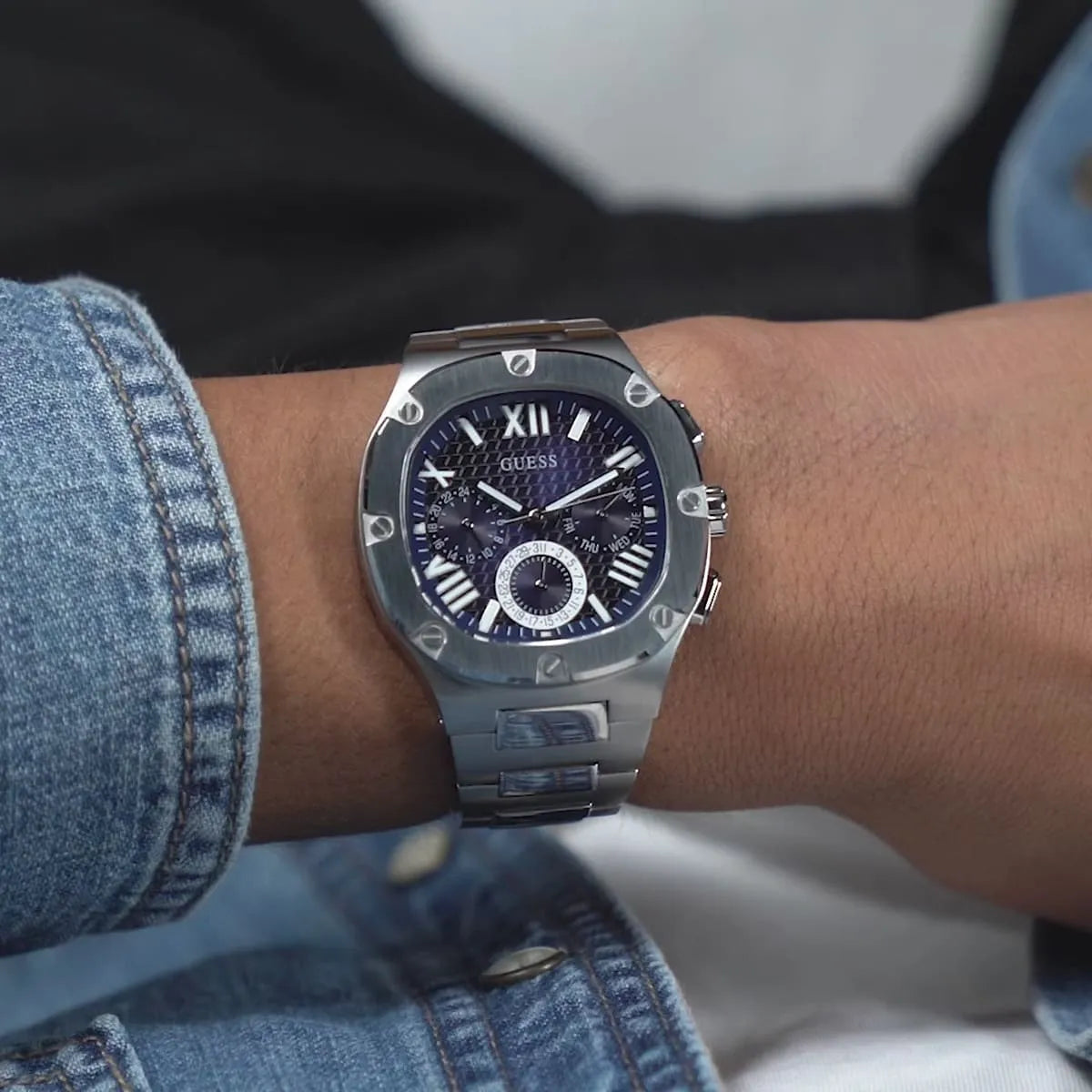 Guess Headliner multifunction chronograph watch worn on wrist with blue face