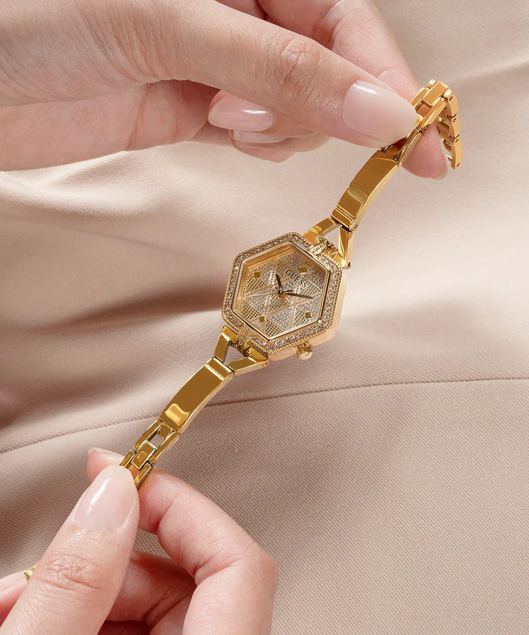 GUESS gold watch held in hand showing champagne patterned dial and strap