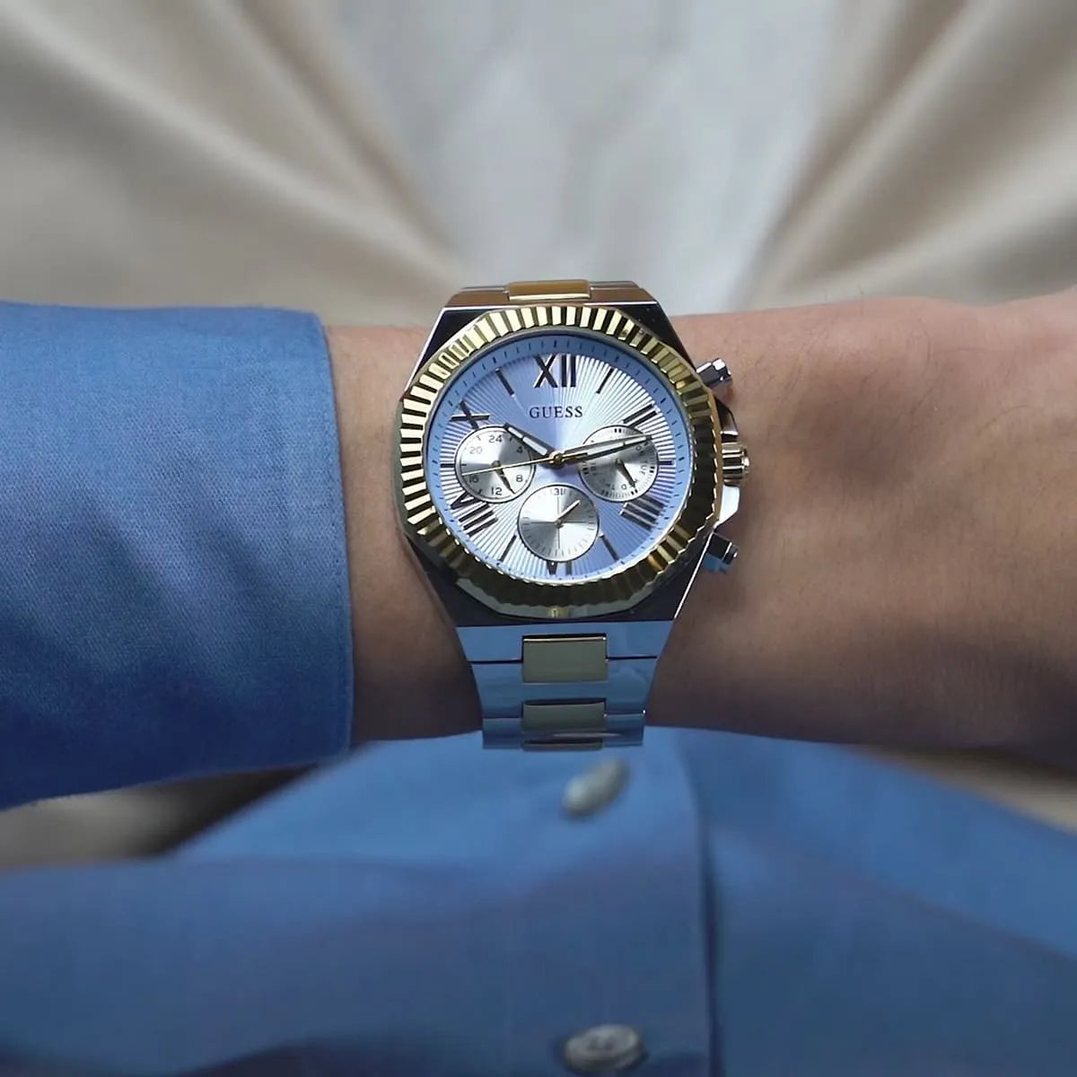 GUESS Equity men's watch worn on wrist with blue dial and chronograph subdials visible