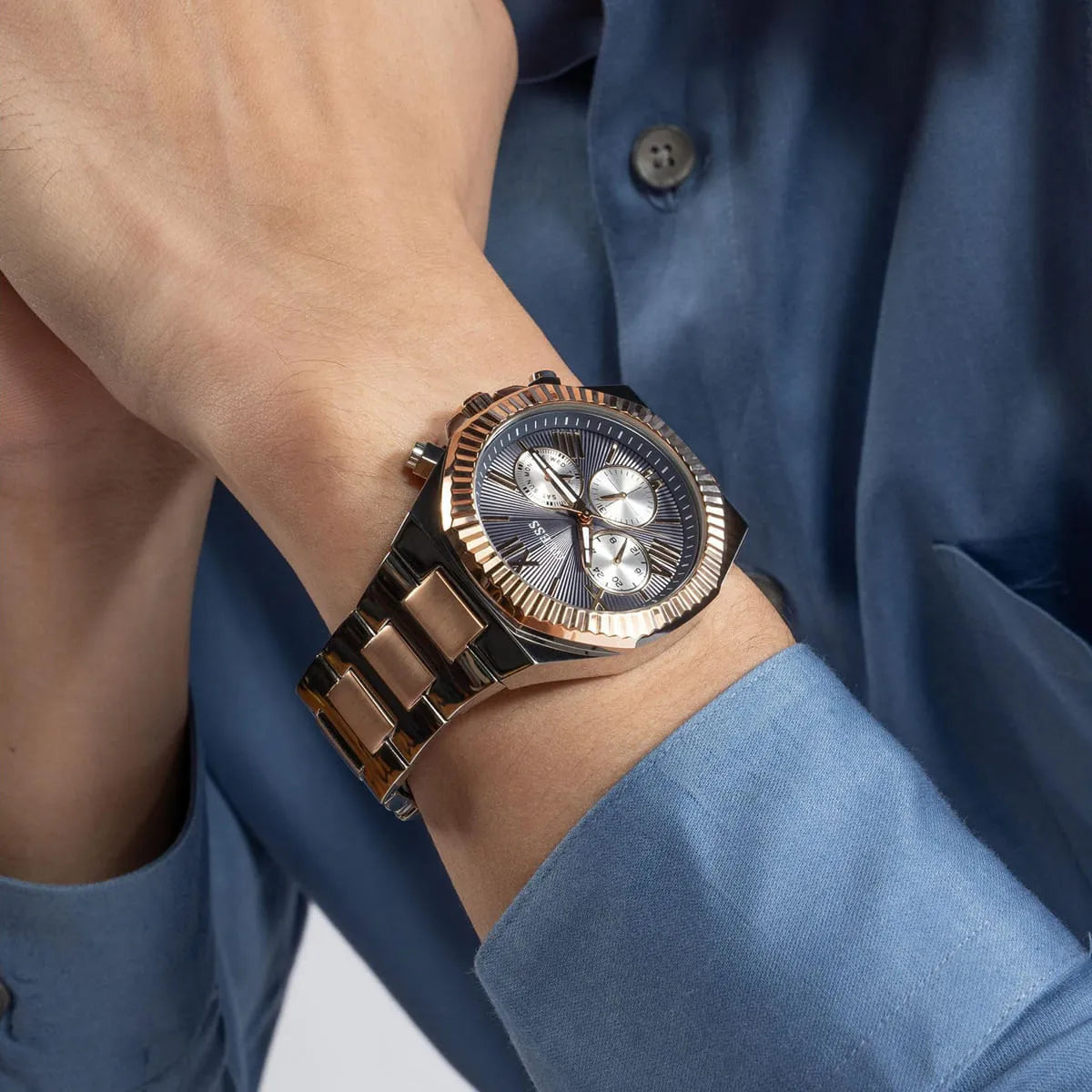 GUESS Equity chronograph watch on wrist with black dial and rose gold bezel detail