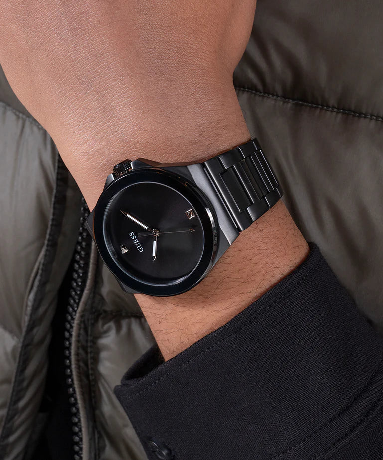 GUESS GW0833G2 black analog watch worn on wrist with gunmetal bracelet