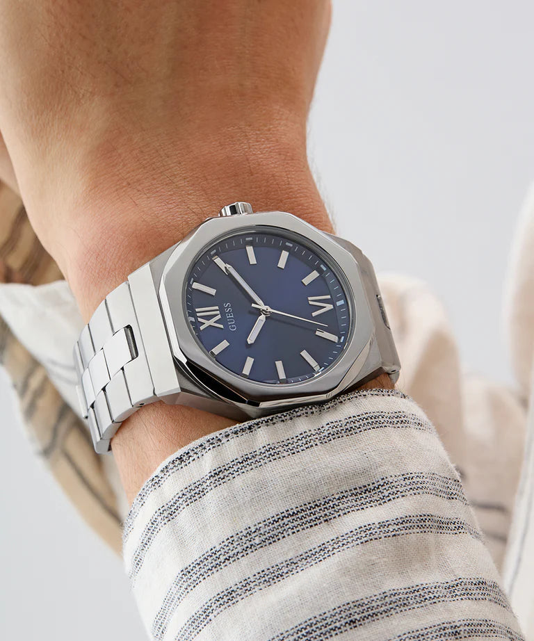 GUESS mens watch on wrist displaying blue dial with white markers and indices