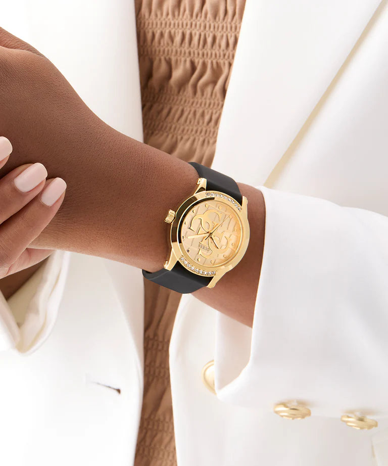 GUESS gold tone ladies watch worn on wrist with black leather strap