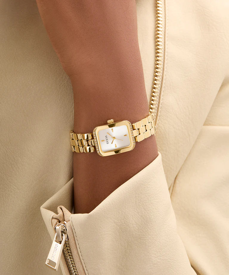 GUESS gold tone ladies watch worn on wrist showing rectangular dial and gold bracelet