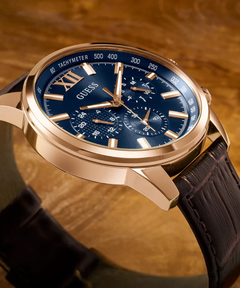 Close-up of GUESS GW0901G3 dial with navy blue face, rose gold Roman numerals, chronograph subdials and tachymeter