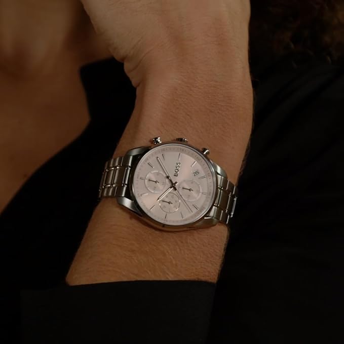 Hugo Boss chronograph watch with pink dial worn on wrist, showing stainless steel case and bracelet