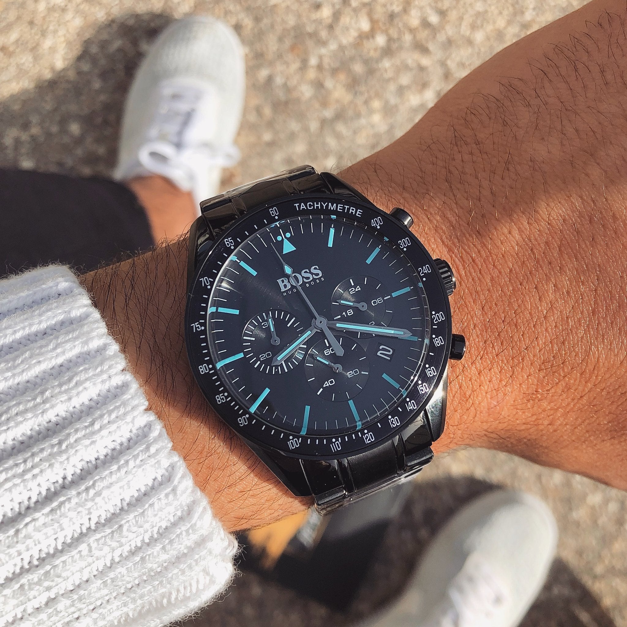 Black chronograph watch worn on wrist showing dial with blue indices and subdials