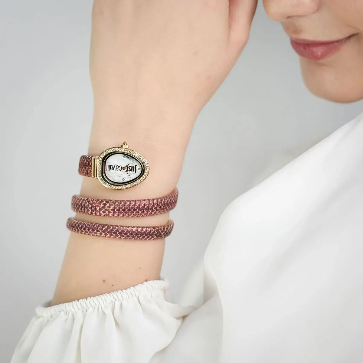 Just Cavalli Glam Snake women's watch on wrist showing white dial and multicolor snake-patterned triple-wrap strap