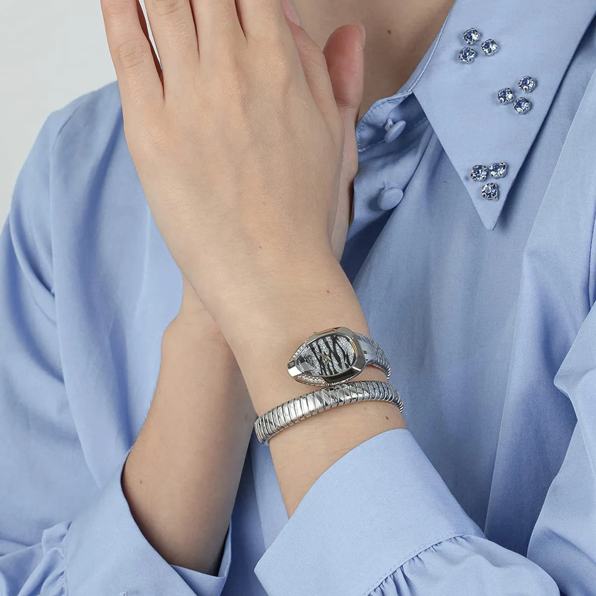 Just Cavalli Signature Snake women's watch worn on wrist with silver snake bracelet wrapped around arm