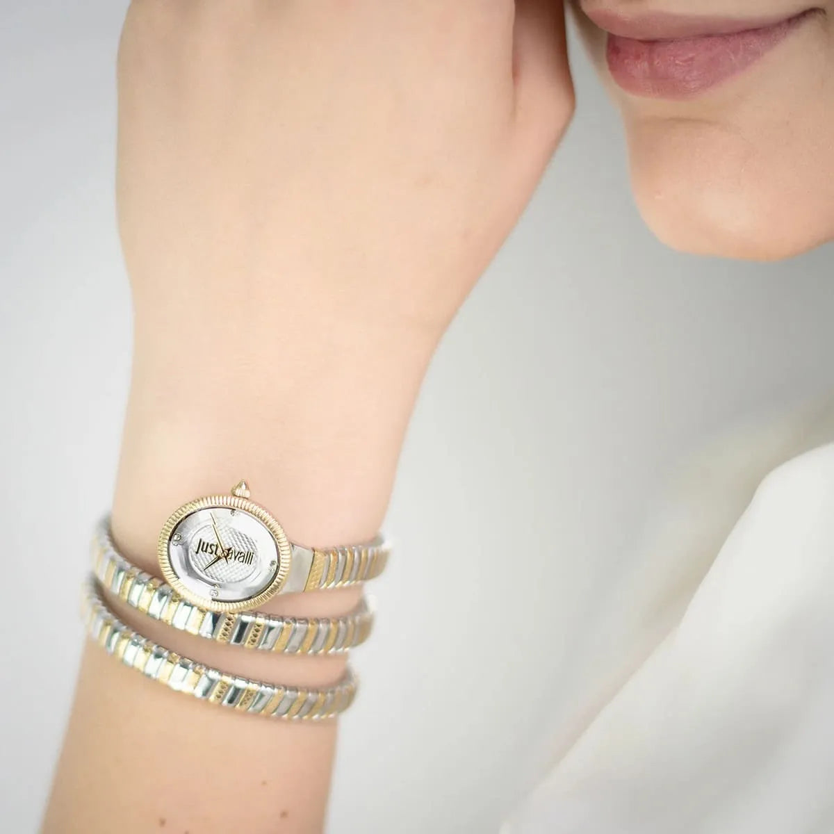 Just Cavalli After Party women's watch worn on wrist with triple-wrap two-tone gold and silver bracelet strap