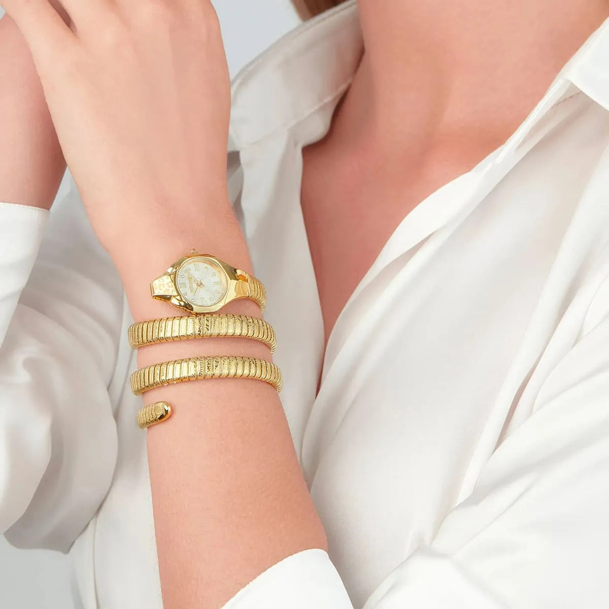 Just Cavalli Ravenna gold watch worn on wrist with triple-wrap snake strap