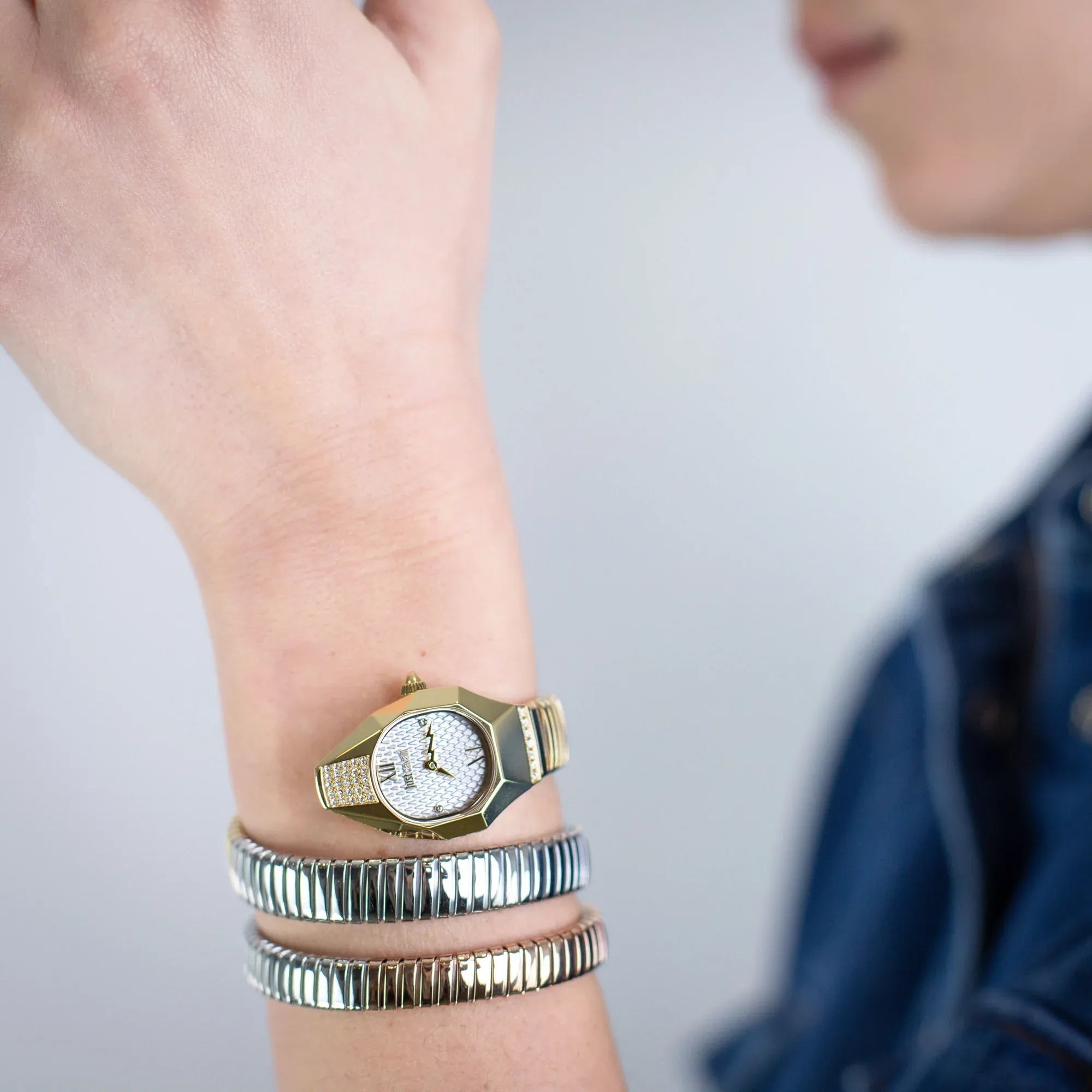 Just Cavalli Signature Snake watch worn on wrist with silver and rose gold snake-textured straps stacked