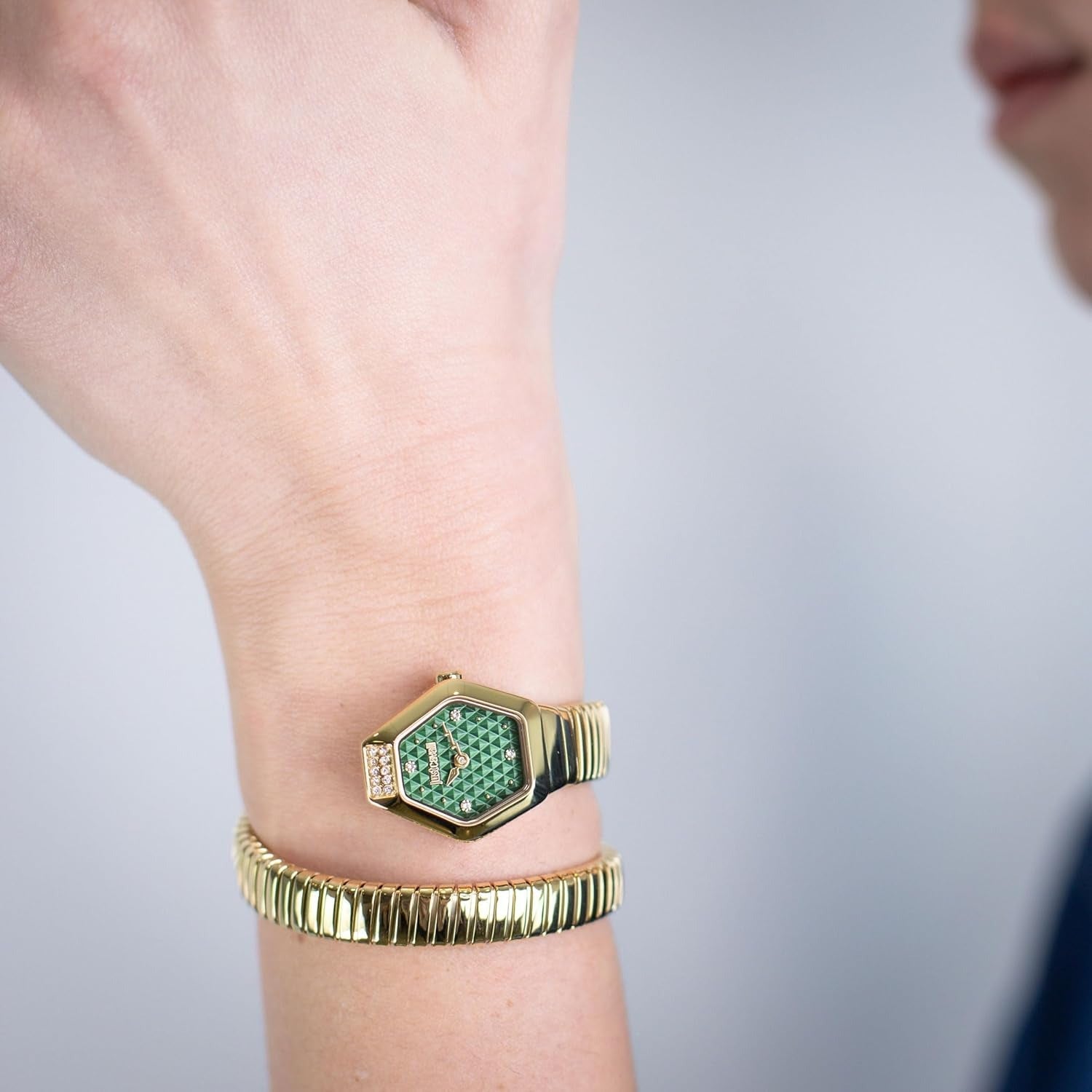 Just Cavalli Signature Snake Splora watch worn on wrist showing yellow gold hexagonal case and green dial