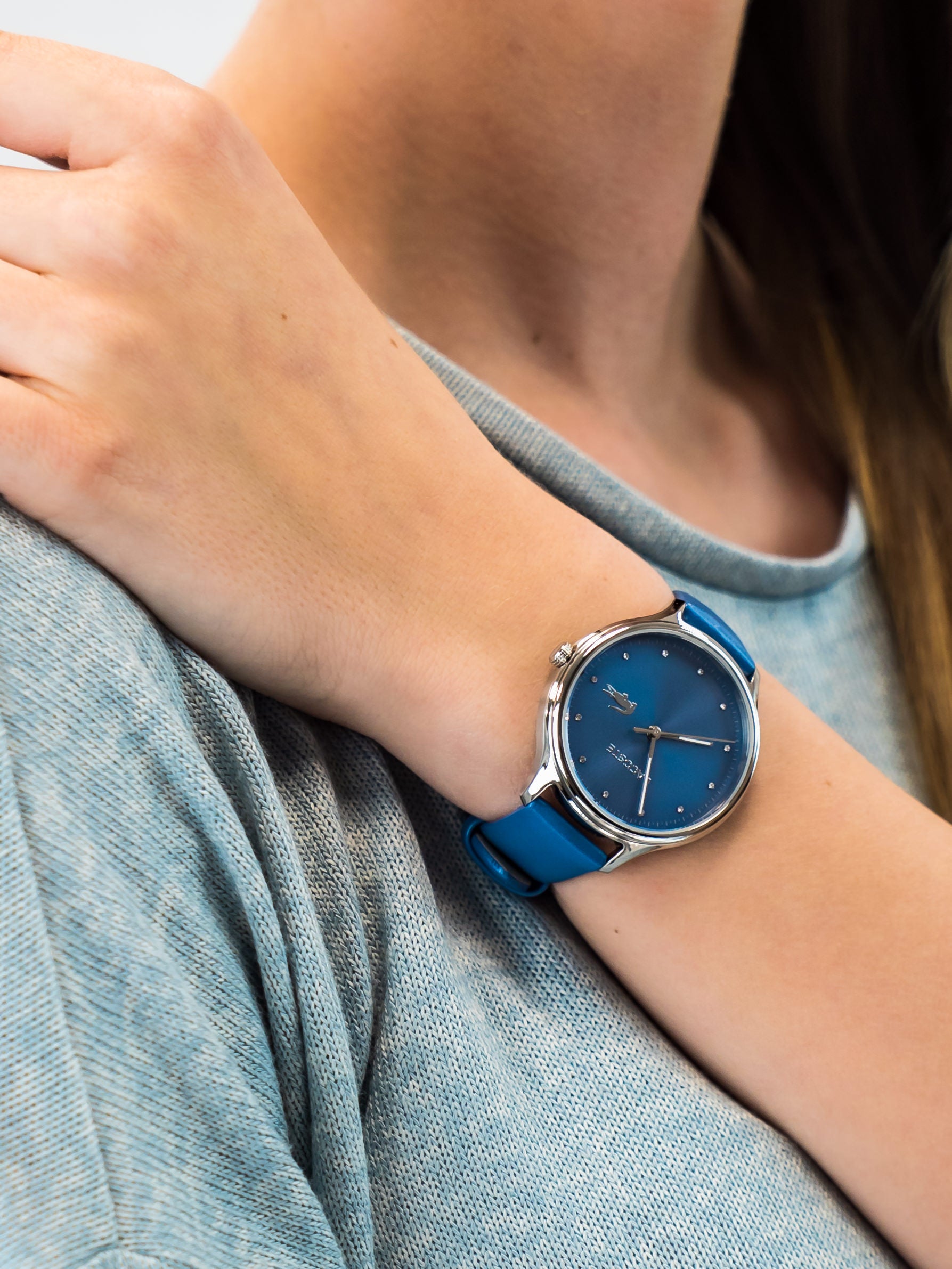 Lacoste watch worn on wrist showing blue leather band and dial
