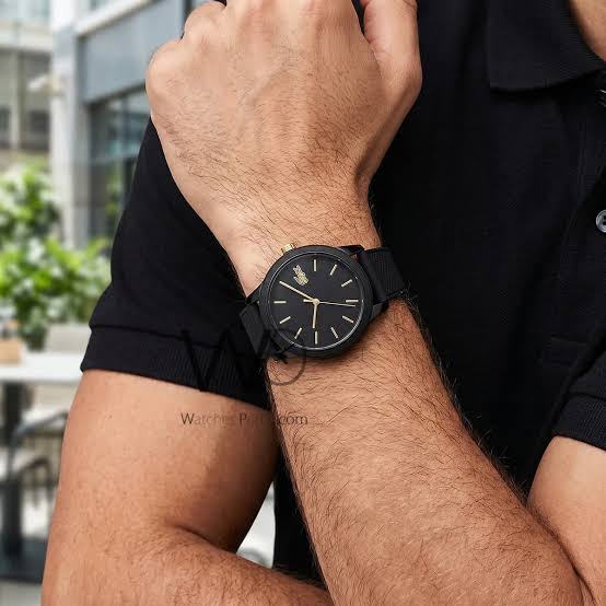 Lacoste analog watch worn on wrist showing black dial and rubber strap in use