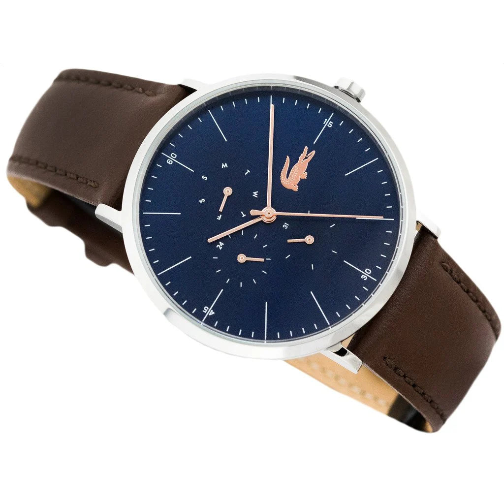 Lacoste Moon Ultra Slim watch at angle showing slim silver case, navy blue dial with multifunction chronograph, and brown leather strap