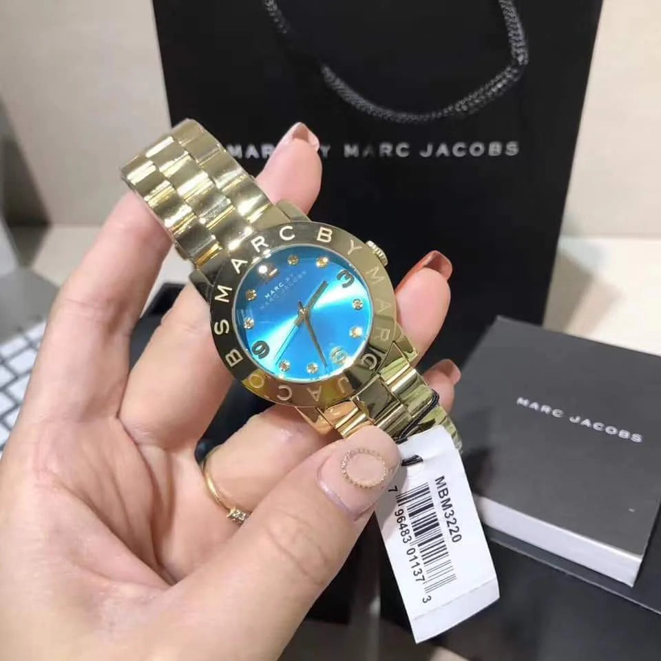 Marc by Marc Jacobs Amy blue watch worn on wrist with Marc Jacobs shopping bag and box