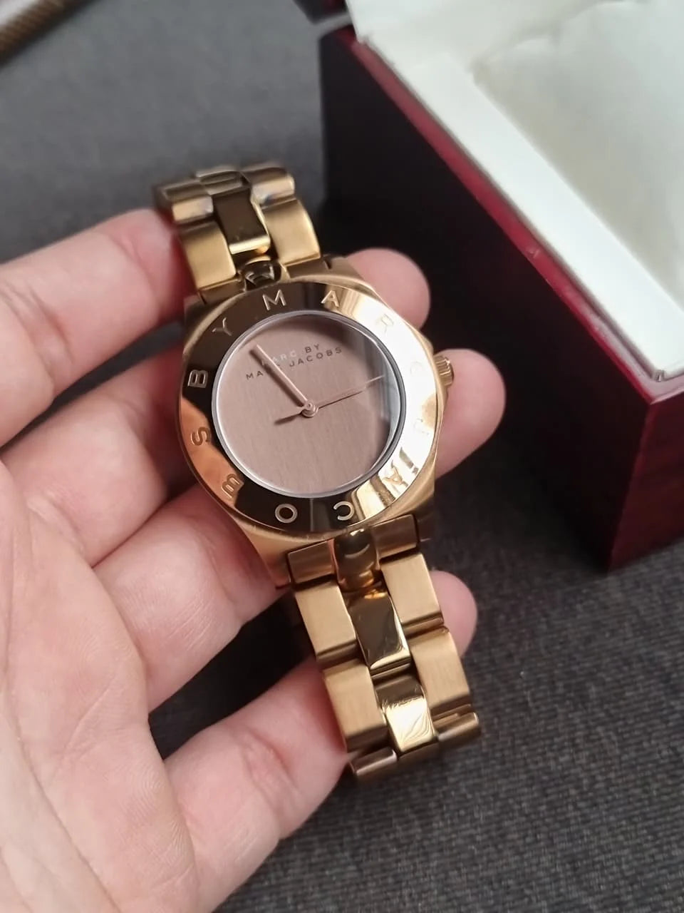 Marc by Marc Jacobs Amy rose gold watch held in hand showing dial and rotating bezel