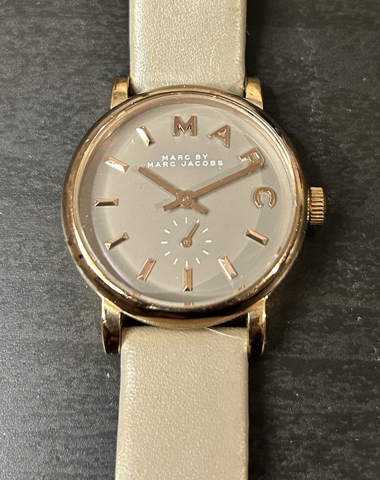 Dial detail of Baker watch showing grey face with rose gold hands and indices