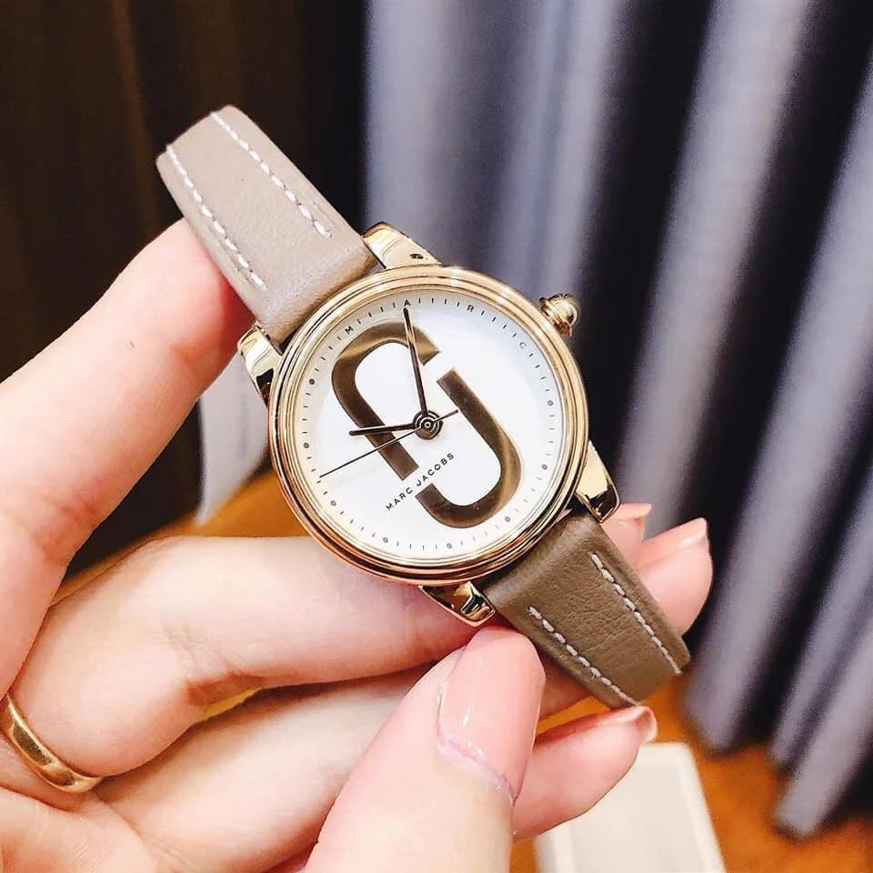 Marc Jacobs Corie watch worn on wrist displaying white dial with rose gold MJ logo