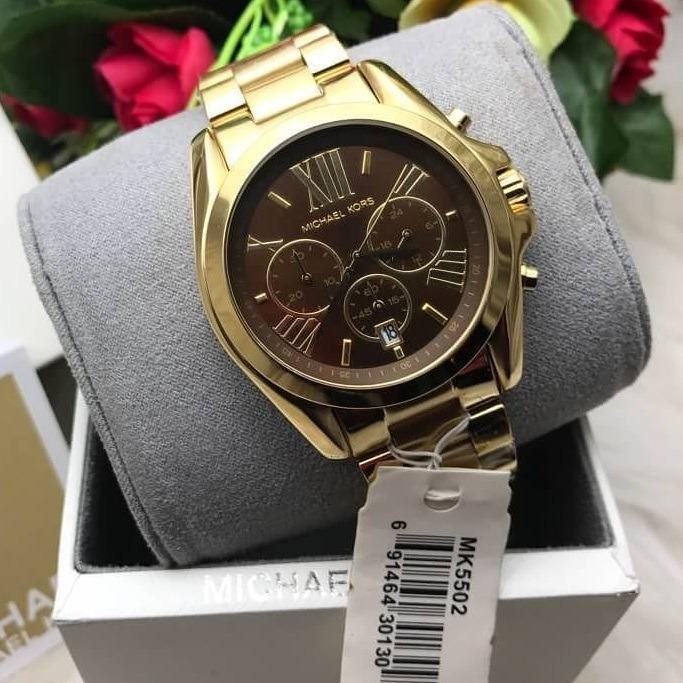 Michael Kors Bradshaw watch displayed on cushioned gift box with flowers