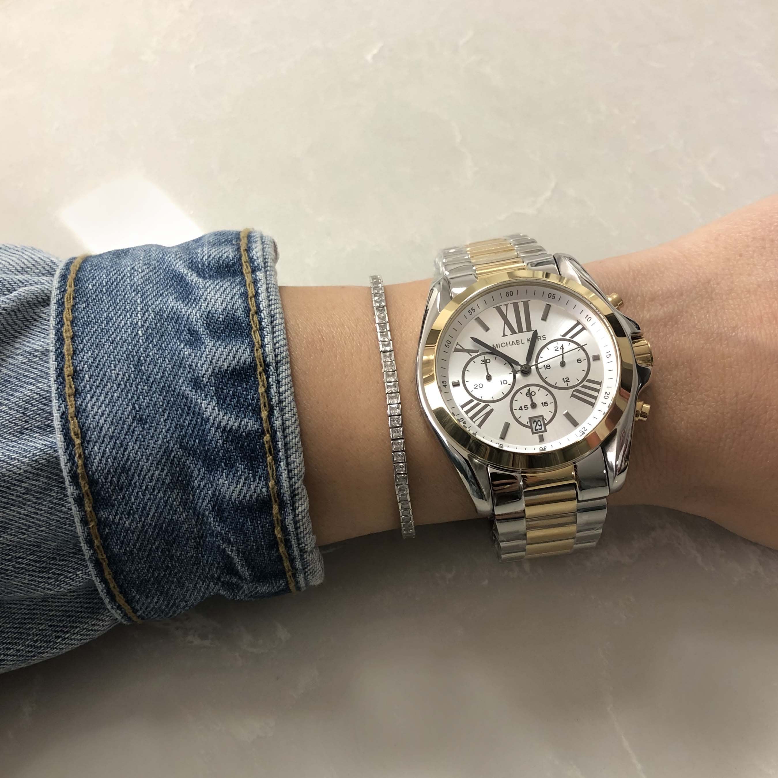 Michael Kors Bradshaw chronograph watch on wrist showing white dial and two-tone design
