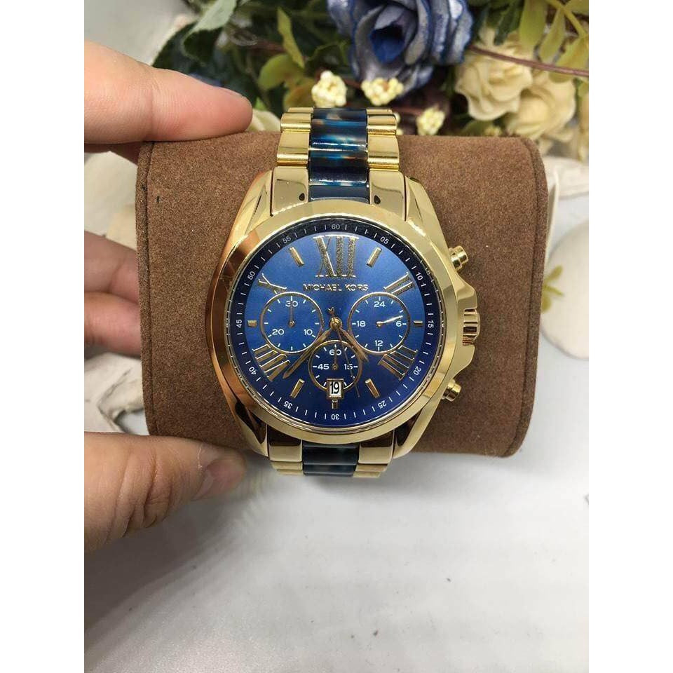 Michael Kors Bradshaw watch worn on wrist with blue dial and gold tone case