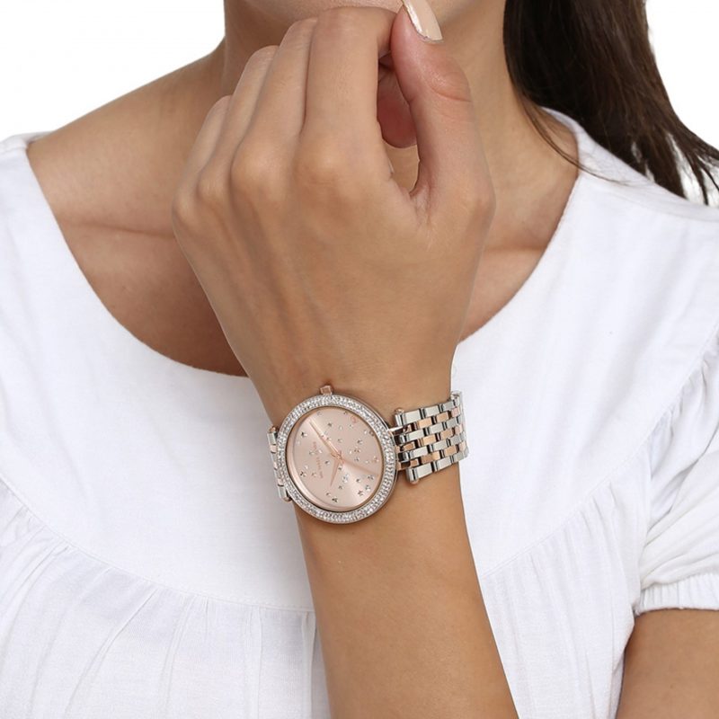 Rose gold and silver Darci watch worn on wrist over white long-sleeve shirt