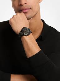 Michael Kors Prescott chronograph watch worn on wrist with black dial and steel bracelet