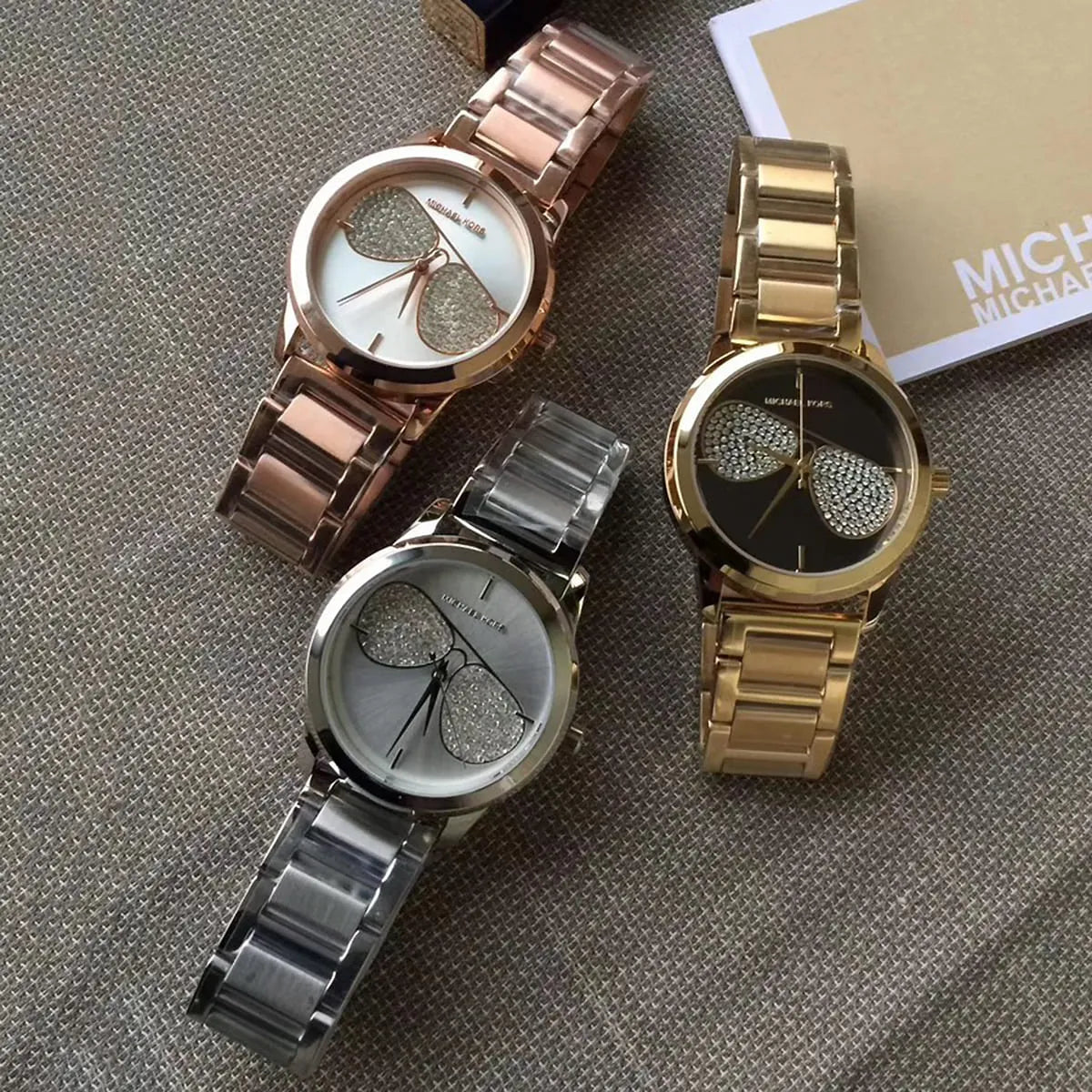 Multiple Michael Kors MK3673 watches displayed showing different dial color variants with packaging