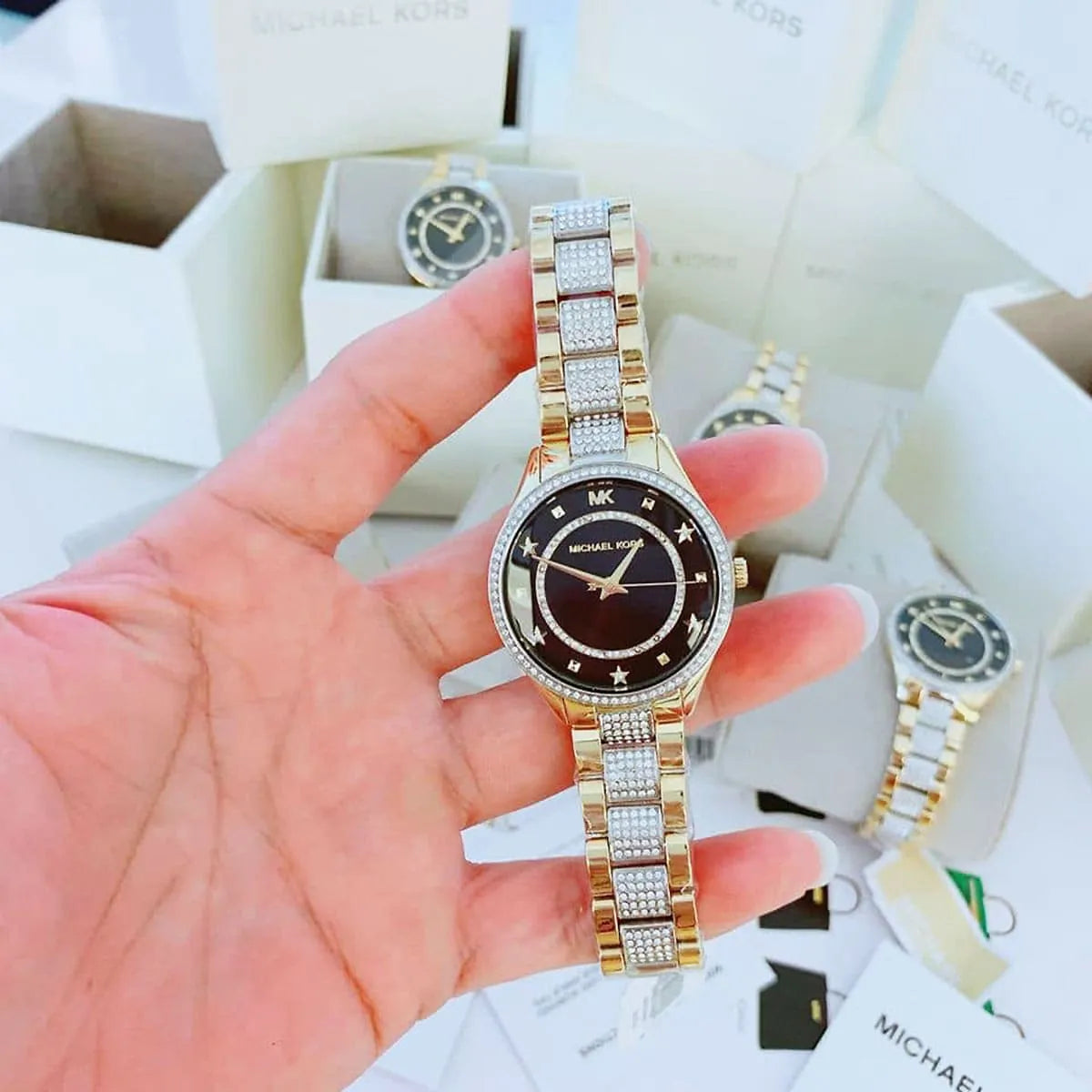 Michael Kors Lauryn watch held in hand showing crystal pave details and black dial