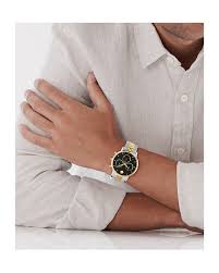Movado black dial watch with rose gold and steel case worn on wrist