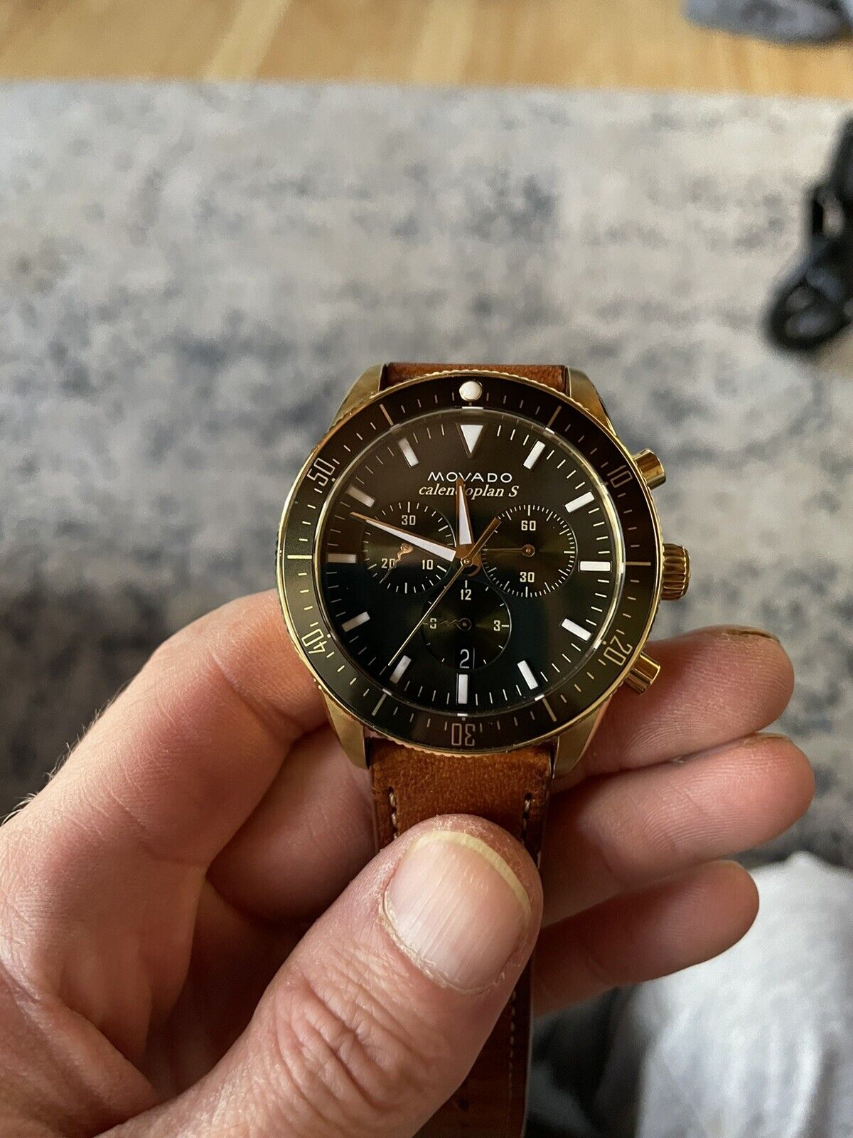 Movado Heritage Chronograph black dial chronograph watch worn on wrist with brown leather strap