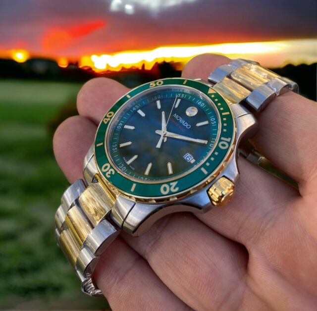 Movado Series 800 green dial watch worn on wrist at sunset